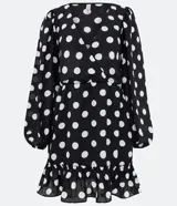 Vestido corto negro con lunares blancos, escote en pico, mangas largas abullonadas, cintura entallada y volados en el bajo.