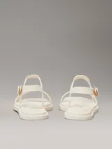 Sandalias Calvin Klein de goma color crema, con tira delantera y tira trasera ajustable con hebilla.