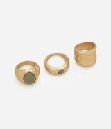 Set de tres anillos dorados con efecto martillado y detalle de resina color verde.