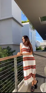 Vestido tejido de algodón crudo con rayas horizontales rojas y escote redondo.