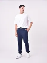 Pantalón de jogging negro con cintura elástica y cordón ajustable. Corte holgado con puños elásticos en los tobillos.