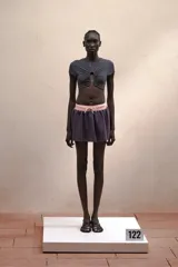 Top gris de manga corta con abertura en el centro del pecho y aplique metálico.