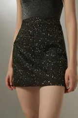 Minifalda negra con estampado de lunares blancos.