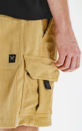 Bermuda cargo color arena de corderoy liviano, con bolsillos amplios con solapa, fuelle, detalles en cinta gross, elástico en la cintura y calce oversize.