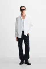 Camisa blanca de algodón, corte slim fit, cuello italiano, manga larga con puños abotonados y cierre frontal con botones.
