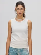 Musculosa crop blanca de algodón con textura acanalada y cuello redondo. Presenta un pequeño logo bordado en el centro del pecho.