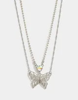 Collar doble plateado con cadena de eslabones y cadena de bolitas. Dije de corazón con efecto iridiscente y dije de mariposa calada.
