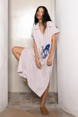 Túnica de lino a rayas verticales color lila y blanco, con cuello polo y bordado de un pulpo azul en el frente.