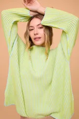 Buzo color crema tejido en algodón, de silueta holgada, mangas anchas y cuello bote.