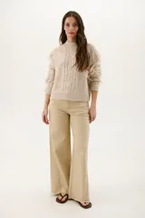 Pantalón de jean acampanado color caramelo con cintura alta y cinturón marrón con tachas.