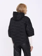 Campera negra corta con cuello alto, cierre frontal con cremallera y mangas 3/4.