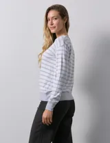 Buzo de modal estampado a rayas horizontales rosas y blancas, con cuello redondo y puños acanalados.