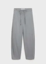 Pantalón largo de tiro medio color gris, estilo jogger, con dos bolsillos laterales, cierre oculto de botón, gancho y cremallera, y forro interior.