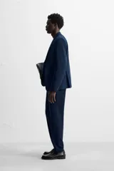 Pantalón de vestir negro slim fit, confeccionado en tejido con viscosa. Cuenta con bolsillos frontales y traseros de vivo. El cierre es frontal con cremallera y botón.
