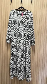 Vestido largo de algodón color blanco con estampado geométrico negro, corte amplio y mangas largas.