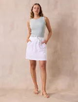 Skort blanco de algodón, marca Erika. Falda con pretina elastizada, lazo de ajuste y bolsillos laterales verticales. Incluye short interno.
