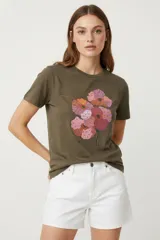 Remera color verde militar de manga corta y cuello redondo, con estampado de flores en tonos naranja, rosa y lila.