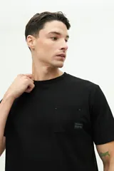 Remera negra de manga corta con bolsillo frontal y logo estampado.