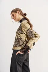 Saco corto dorado con lentejuelas y bordados con motivos geométricos y corazones.