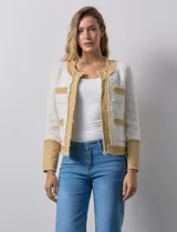 Chaqueta Nanette en tejido tweed color crudo con detalles en denim azul. Tiene cuello a la base, abertura central, bolsillos delanteros, puños con aplique de botones perlados, terminación desflecada y forro interno.