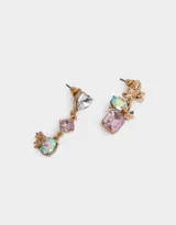 Aros colgantes cortos dorados con strass en distintas formas y tonalidades. Uno de los aros tiene una abeja dorada en la parte superior, seguido de una piedra ovalada multicolor, una flor dorada y una piedra rectangular color lila. El otro aro tiene una piedra en forma de corazón transparente, una piedra cuadrada color lila y una piedra ovalada multicolor con flores doradas.