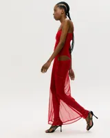 Conjunto de lencería rojo transparente, compuesto por un body con breteles finos y una falda larga de red con abertura lateral.