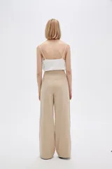 Pantalón de lino color beige, de corte recto y tiro alto, con bolsillos laterales.
