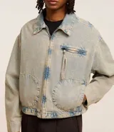 Campera overboxy de jean celeste con efecto lavado, cuello inglés, cierre frontal con cremallera, manga larga y bolsillo con cierre en el pecho. Confeccionada con algodón BCI más sostenible.
