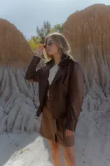 Campera de cuero marrón chocolate con acabado vintage, cuello solapa con piel de corderito desmontable, avíos metálicos en bronce viejo, cinto con hebilla para ajustar la cintura, cierres funcionales en puños y bolsillos laterales e interior forrado.