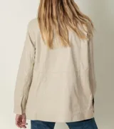 Campera de cuero ovino color beige, con cierre frontal y broches, diseño entallable con cinta interna.
