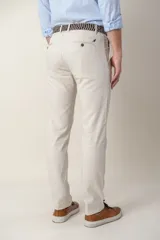 Pantalón color beige de corte slim fit confeccionado en tencel, un tejido suave derivado de la celulosa de la madera que regula la temperatura.