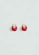 Aros de acrílico rojo con apliques metálicos dorados.