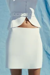 Minifalda blanca de punto liso, tiro alto, cintura elástica y corte evasé.