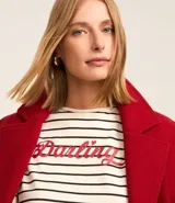 Remera boxy de algodón y poliéster a rayas horizontales blancas y negras, con cuello redondo y mangas cortas. Estampa frontal con la palabra "Darling" en color rojo.