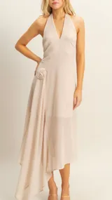 Vestido largo color beige, con escote halter y detalle de rosa en el lateral.