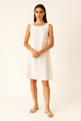 Vestido blanco de lino, corte recto, sin mangas y cuello redondo.