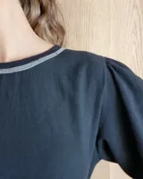 Remera negra de mangas largas con detalle de costuras en color gris en cuello y ruedo.
