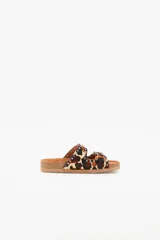 Sandalias de cuero vacuno con estampado animal print, forro de cuero vacuno y suela de caucho. Presentan dos tiras con hebillas ajustables y apliques de tachas metálicas.