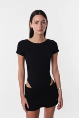 Body negro de algodón con lycra, cuello redondo y espalda descubierta. Mangas cortas y calce slim.
