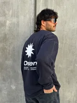 Buzo negro de corte holgado con estampa en la espalda que incluye una estrella blanca, la palabra "Osen" y las palabras "Empower", "Elevate", "Boldness" y "Strength".