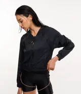 Campera deportiva rompevientos negra, confeccionada en poliamida, con capucha, cierre delantero en cremallera, tirador gomoso y puños ajustados.