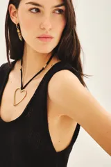 Top sin mangas color negro con escote en U pronunciado, tejido en punto compacto de textura sedosa y brillante.