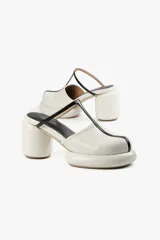 Mule color caramelo con plataforma y taco cilíndrico, tira superior negra y puntera cuadrada.
