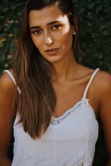 Camisón corto negro de satén con breteles finos y escote en V con puntilla blanca.