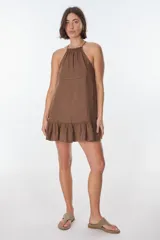 Vestido corto color beige, con escote halter, tirantes finos y falda con volados.
