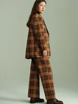 Blazer oversize con estampado cuadrillé en tonos marrones y amarillos, con cuello de terciopelo negro, dos bolsillos delanteros y forro de satén.