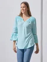 Blusa color celeste con escote en V, mangas largas acampanadas con detalle de crochet.