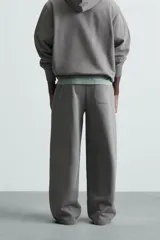 Pantalón jogger wide fit negro confeccionado en tejido de algodón con interior rizo. Pernera ancha, cintura elástica ajustable con cordón interior, bolsillos laterales y bolsillo trasero de plastrón.