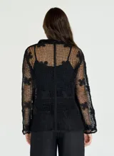 Camisa beige de crochet con cuello clásico, manga larga y cierre frontal con botones.