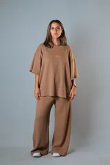 Conjunto de dos piezas color marrón claro, confeccionado en punto Prato. Incluye remera de manga corta con bordado y pantalón palazzo de calce relajado con cintura elastizada.